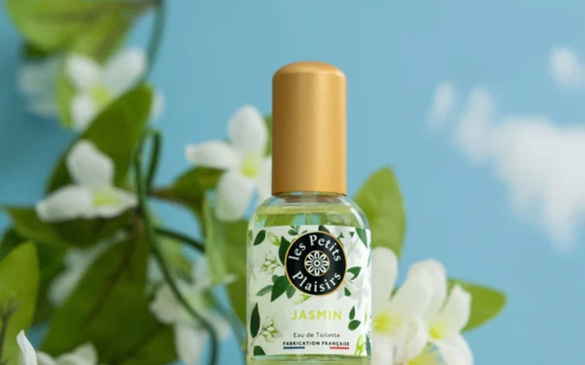 Eau de toilette Les Petits Plaisirs au jasmin, présentée avec des fleurs blanches, illustrant une option de parfum accessible à petit prix pour un usage quotidien